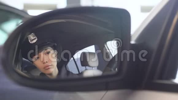 自信的女警察戴上太阳镜看汽车后视镜视频的预览图