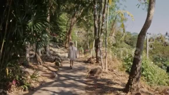 小女孩在热带地区走乡间小路视频的预览图