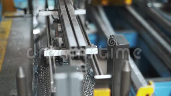 机器人机械手在工厂内移动穿孔金属片清洗滚筒视频的预览图