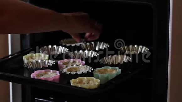 一个女人把烤饼从烤箱移到盘子里表格在烤盘上视频的预览图