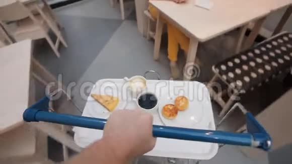 人在餐馆里用手推车搬运食物然后放到桌子上视频的预览图