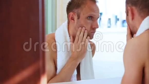 年轻的成年男子在刮胡子前脸上有泡沫视频的预览图