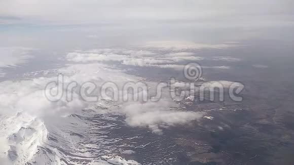 从飞机舷窗上看到云层和雪山视频的预览图