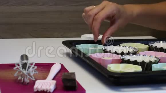 女人用糕点摇动蛋糕使面团均匀分布附近有制作甜点的工具视频的预览图
