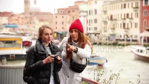 两名年轻女子在威尼斯街头拍摄周围环境视频的预览图
