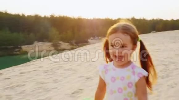 慢镜头欢快无忧无虑的女孩三年在沙滩上奔跑在这种背景下视频的预览图