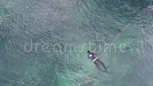 从上面看到的潜水员在海里游泳一个穿着潜水服的人潜入水中猎鱼视频的预览图