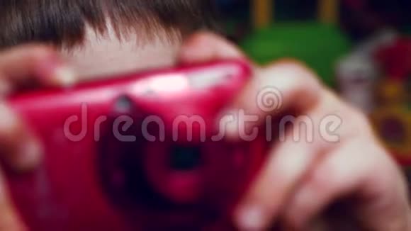 年轻电影制作人手中的红色相机学龄前学生的眼睛媒体设备神秘的背景青年视频的预览图