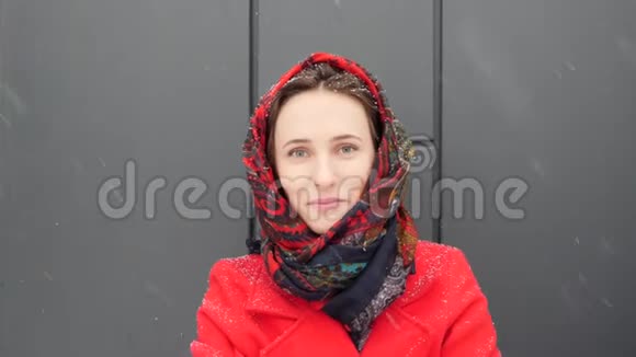 这段视频是关于美丽的年轻白种人女人裹着温暖的红色外套带着牙套对着镜头微笑视频的预览图