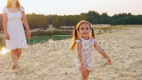stadicam镜头快乐的童年妈妈和女儿在海滩上玩耍女孩笑了跑开了视频的预览图