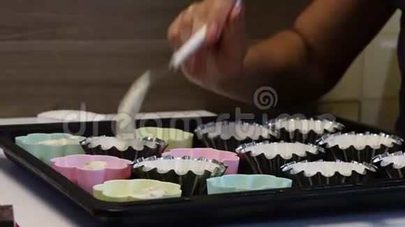 一个女人把面团放在蛋糕的烤盘里附近有制作甜点的工具视频的预览图