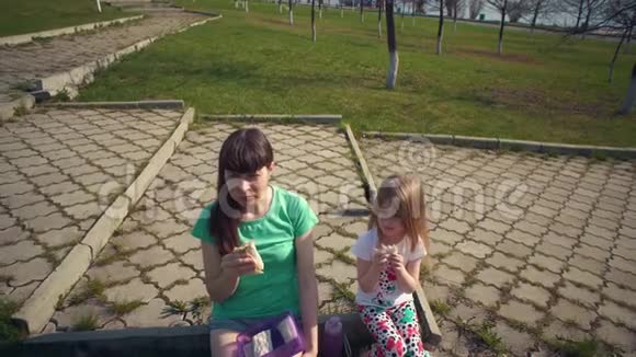 妈妈和可爱的女儿在户外吃沙瓦玛视频的预览图