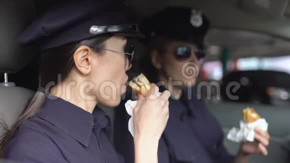 值班女警察在巡逻车上吃汉堡饮食不健康视频的预览图