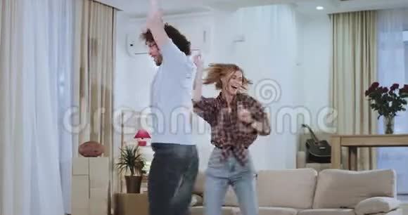 一对漂亮的年轻夫妇在新房子公寓搬家一天后在客厅里跳舞他们享受在一起的时光视频的预览图