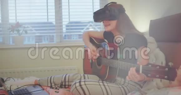 一位弹吉他的女士的肖像用她的虚拟现实眼镜她用新技术来感受更多视频的预览图