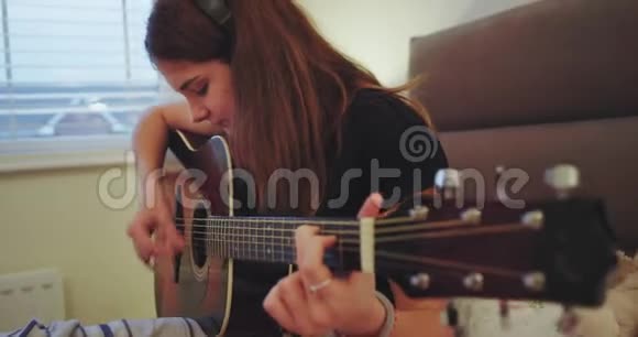一位魅力非凡的少女在卧室里弹吉他她觉得很享受时光视频的预览图