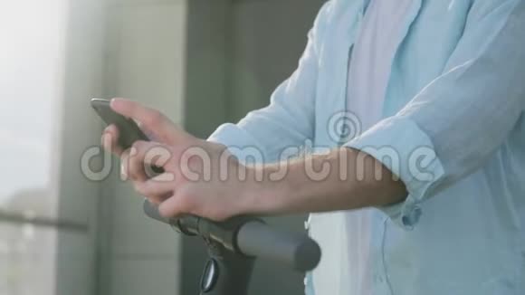 一个带电动滑板车的人在户外用手机视频的预览图