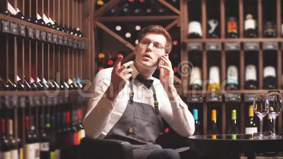 优雅的年轻侍酒师和买家通电话视频的预览图