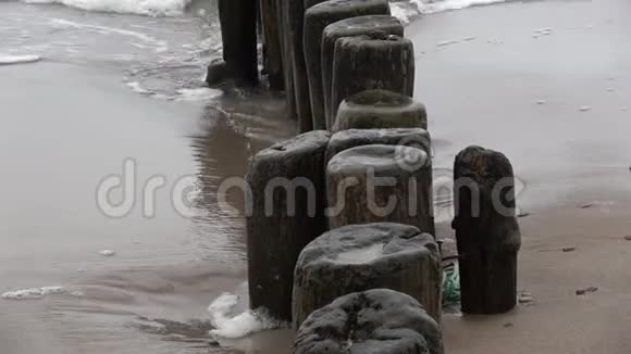 破旧的木柱码头上的木桩碎片和波浪视频的预览图