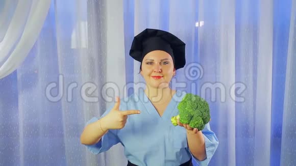 一位女厨师微笑着手里拿着一颗西兰花白菜指着它视频的预览图