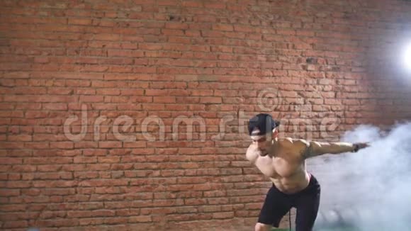 肌肉男在黑暗的健身房里练习跳跃运动视频的预览图
