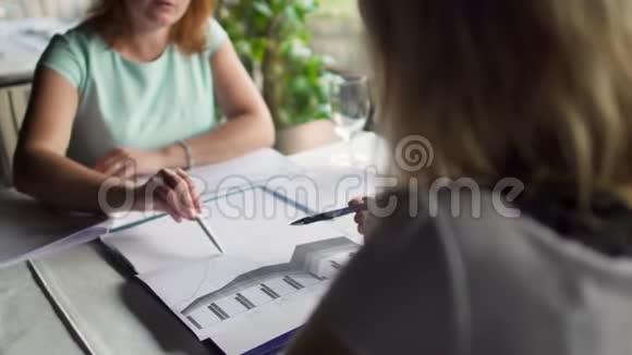 两位成年妇女在餐馆里开商务会议和写文件视频的预览图