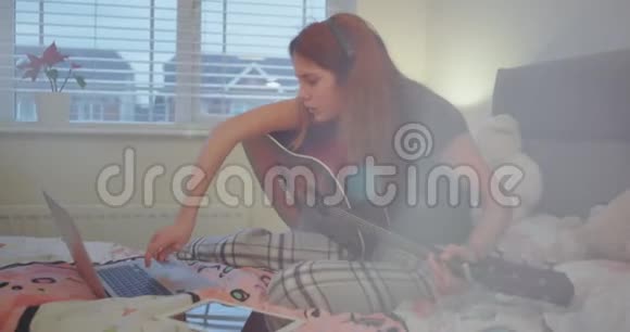 特写集中在卧室的女孩准备一个笔记本开始弹吉他她非常喜欢视频的预览图