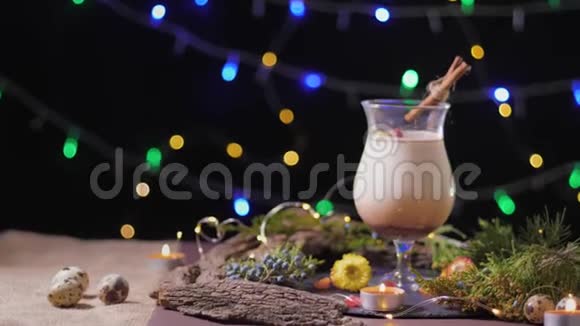 节日餐桌一个漂亮的玻璃杯传统的鸡蛋鸡尾酒装饰着圣诞树和彩灯蛋酒视频的预览图