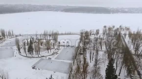 冰湖和冬季公园的鸟瞰图人们在公园里放松滑冰和打曲棍球活跃的寒假视频的预览图