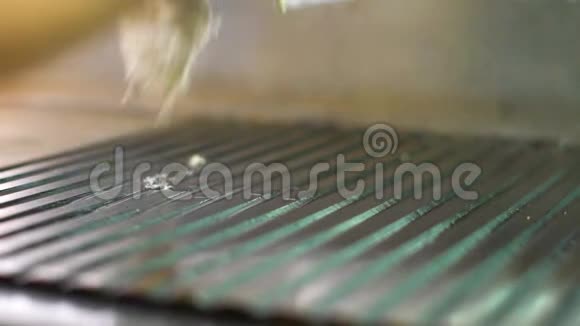 厨师用毛巾将烤架表面多余的油擦干净视频的预览图