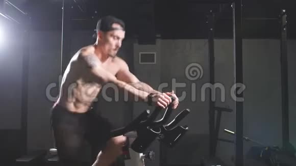 裸胸运动员在健身房从事自行车模拟器视频的预览图