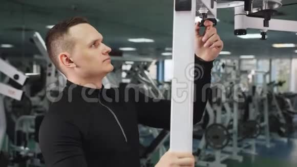 在健身房锻炼手臂前男人要调整三头肌视频的预览图