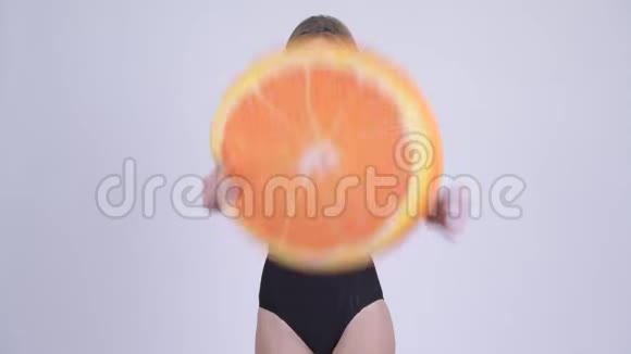 一位年轻的金发美女穿着泳装把橙色的枕头扔给健康的人视频的预览图