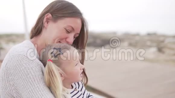 妈妈和她的小女儿正坐在海滩上视频的预览图