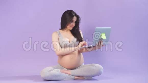 位于莲花位置的孕妇用手提电脑键盘输入信息视频的预览图