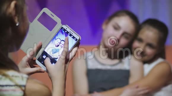 使用手机和拍女友照片的少女视频的预览图