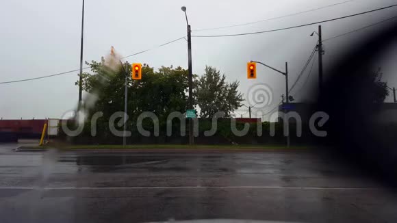 司机的观点POV等待红灯时下雨在道路交叉路口等待绿灯视频的预览图