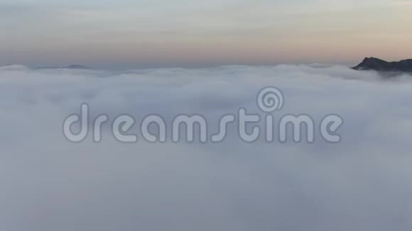 日落后飞越云层和山峰眺望大海视频的预览图