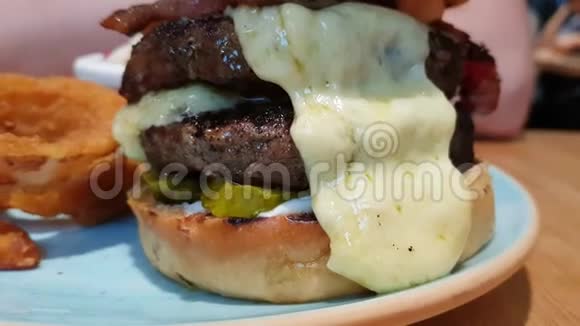 大的开胃汉堡双肉切洋葱圈泡菜融化的奶酪和培根餐厅里有汉堡视频的预览图