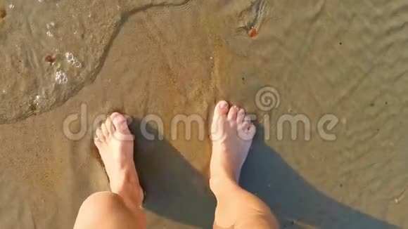 穿着粉红色裙子的女性光着脚在水中行走海浪袭来自然放松视频的预览图