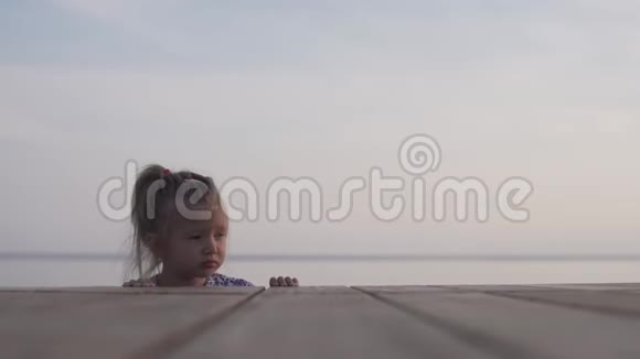 日落时分美丽的小女孩走在海边视频的预览图
