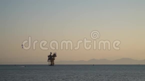 埃及一个人正在海上一个巨大的石油钻井平台附近玩风筝冲浪视频的预览图
