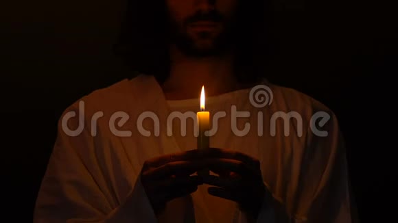 耶稣基督在黑暗中点燃蜡烛带来希望和信心视频的预览图