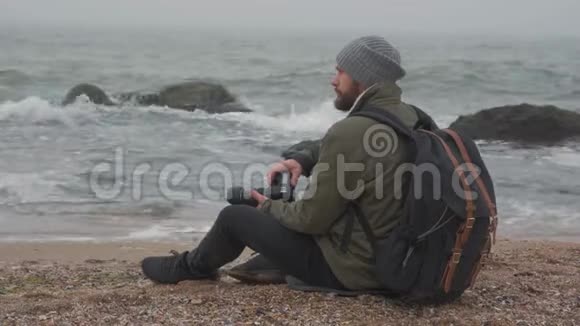 大胡子在海洋前用专业照相机拍照视频的预览图