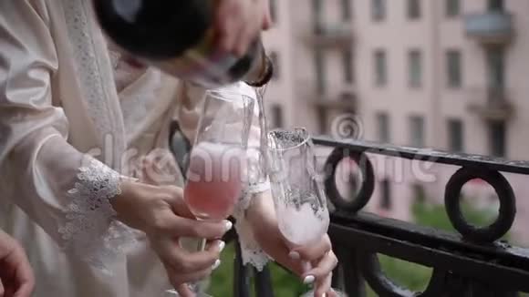 年轻夫妇打开一瓶香槟在阳台上倒入玻璃杯酒精饮料和饮料视频的预览图