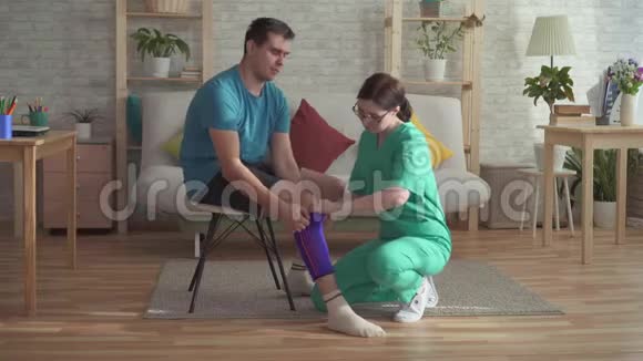 护士帮一个男子运动员的膝盖包扎视频的预览图