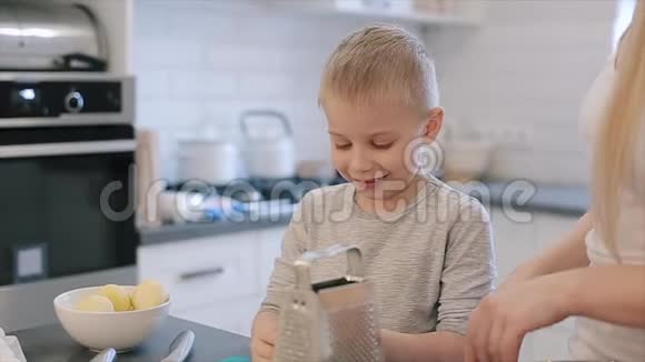 可爱的白种人男孩大蓝眼睛吃奶酪而厨房年轻的母亲可爱的美丽视频的预览图