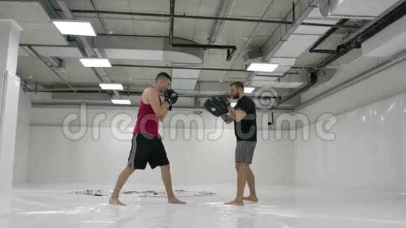 踢拳者配合训练者完成了乳房的斜坡和爪子的缓慢动作视频的预览图