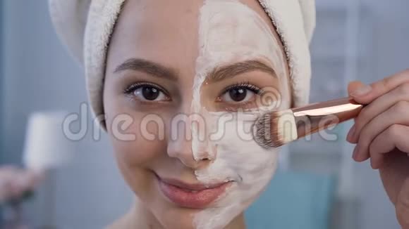 漂亮的年轻女子在脸上敷面膜的特写镜头视频的预览图
