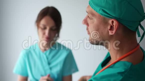 实习生和医生在门诊走廊咨询穿着医用礼服的男人和女人医疗和保健视频的预览图